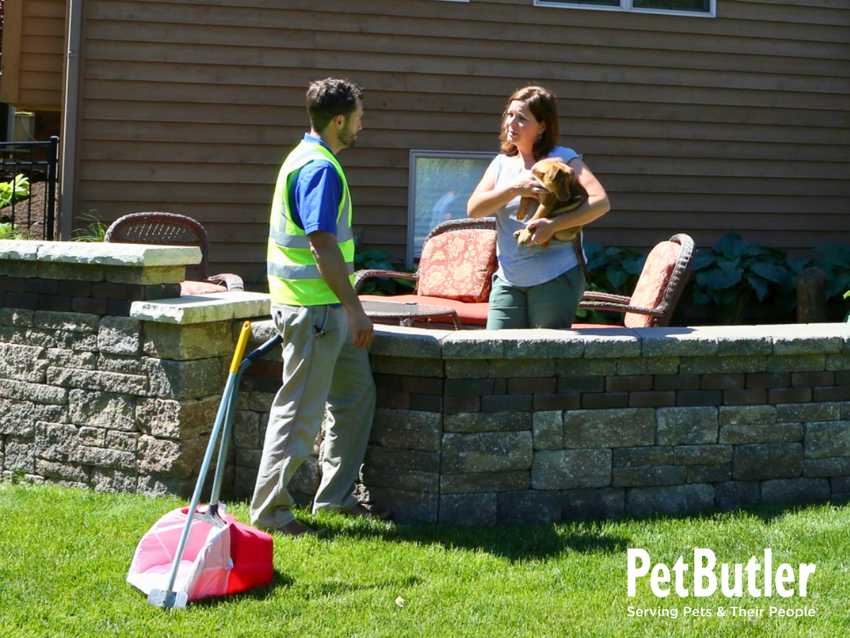 Pet Butler waste removal tech talking with customer while servicing her yard. Building relationship.