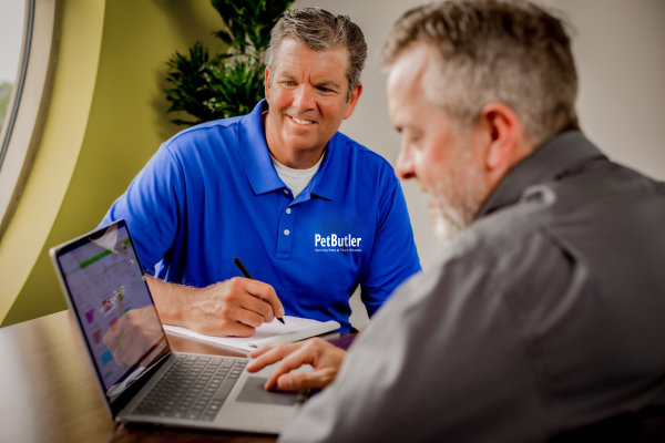Pet Butler consultant sitting down with client and looking at laptop together